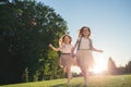 Two joyfull girls running against the sunset.