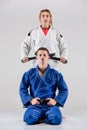 The two judokas fighters posing on gray Royalty Free Stock Photo