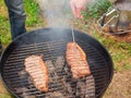 Two juicy beef steaks are grilled on a round grill. Meat readiness check Royalty Free Stock Photo