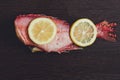 Two juicy lemon slices lie on fresh red fish. The fish is called sea bass. Royalty Free Stock Photo