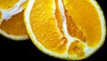 Two juicy oranges cut in half on black background Royalty Free Stock Photo