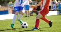 Two junior level soccer players running and kicking a soccer ball Royalty Free Stock Photo