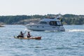 Two kayakers close to flybridgeboat