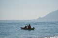 Two kayakers on one kayak in the sea against the backdrop of mountains