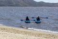 Two kayakers paddling on a windy day close to the beach at Washoe Lake