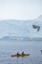 Kayakers by a glacier, Antarctic Peninsula