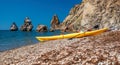 Two kayaks on an isolated rocky beach, against the background of a cliff in the sea. Kayaking along the coast of the island near Royalty Free Stock Photo