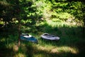 Two kayaks lie on the shore with oars.