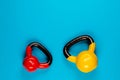 Two kettlebells of different sizes on blue background Royalty Free Stock Photo