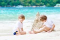 Two kid boys building sand castle on tropical beach Royalty Free Stock Photo