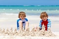 Two kid boys building sand castle on tropical beach of Playa del Carmen, Mexico Royalty Free Stock Photo