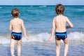 Two kid boys running on ocean beach. Little children having fun Royalty Free Stock Photo