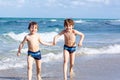 Two kid boys running on ocean beach. Little children having fun Royalty Free Stock Photo