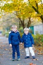 Two kid boys walking together in autumn park Royalty Free Stock Photo