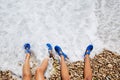 two kid girls legs in a beach foam shore