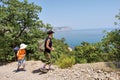 Two kids backpackers, boy n girl, walk next to sea