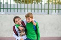 Two kids with backpacks on their backs hug each other looking at the camera. Back to school concept Royalty Free Stock Photo