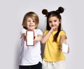 Two kids boy and girl brother and sister playing with mobile phone show blank screen of cellphone with free text copy