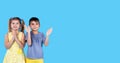 Two kids boy and girl standing next to each other smiling clapping their hands and looking at the camera. Royalty Free Stock Photo