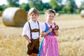 Two kids, boy and girl in traditional Bavarian costumes in wheat field Royalty Free Stock Photo