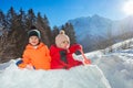 Two kids, boy with sister girl play in snow fortress outside Royalty Free Stock Photo