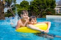 Two kids boys having fun on inflatable rubber rings in outdoor pool. Summer holiday. Summertime kids weekend. Children Royalty Free Stock Photo