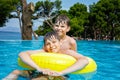 Two kids boys having fun on inflatable rubber rings in outdoor pool. Summer holiday. Summertime kids weekend. Children Royalty Free Stock Photo