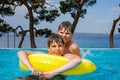 Two kids boys having fun on inflatable rubber rings in outdoor pool. Summer holiday. Summertime kids weekend. Children Royalty Free Stock Photo