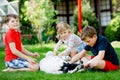 Two kids boys and little toddler girl playing with family dog in garden. Three children, adorable siblings having fun Royalty Free Stock Photo
