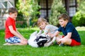 Two kids boys and little toddler girl playing with family dog in garden. Three children, adorable siblings having fun Royalty Free Stock Photo