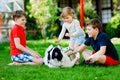 Two kids boys and little toddler girl playing with family dog in garden. Three children, adorable siblings having fun Royalty Free Stock Photo