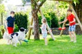 Two kids boys and little toddler girl playing with family dog in garden. Three children, adorable siblings having fun Royalty Free Stock Photo