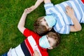 Two kids boys in medical mask as protection against pandemic coronavirus disease. Children, lovely siblings and best