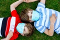 Two kids boys in medical mask as protection against pandemic coronavirus disease. Children, lovely siblings and best