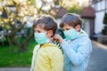 Two kids boys in medical mask as protection against pandemic coronavirus disease. Children, lovely siblings and best