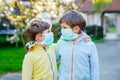 Two kids boys in medical mask as protection against pandemic coronavirus disease. Children, lovely siblings and best