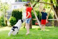 Two kids boys playing with family dog in garden. Laughing children, adorable siblings having fun with dog, with running Royalty Free Stock Photo