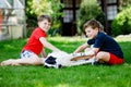 Two kids boys playing with family dog in garden. Laughing children, adorable siblings having fun with dog, with running Royalty Free Stock Photo