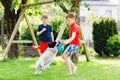 Two kids boys playing with family dog in garden. Laughing children, adorable siblings having fun with dog, with running Royalty Free Stock Photo