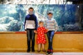 Two kids boys and toddler girl visiting together zoo aquarium. Three children watching fishes and jellyfishes. School Royalty Free Stock Photo