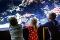 Two kids boys and toddler girl visiting together zoo aquarium. Three children watching fishes and jellyfishes. School Royalty Free Stock Photo