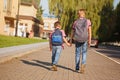 Two kids brothers with backpack holding on hands walking to school. Back view. Royalty Free Stock Photo