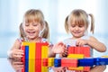 Two kids building with wooden blocks at table.