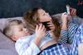 Two kids caucasian boy and girl playing games or looking information video text at Internet on mobile phones at home Royalty Free Stock Photo