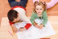 Two kids coloring on the floor
