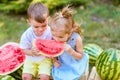 Two kids eating one slice of watermelon in the garden. Kids eat fruit outdoors. Healthy snack for children. 2 years old girl and Royalty Free Stock Photo