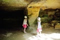 Two kids exploring old caves dug into the tuff rock and used for human habitation in ancient times. Citta del Tufo archaeological
