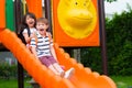 Two kids friends having fun to play together on children`s slide at school playground,back to school activity Royalty Free Stock Photo