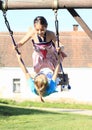 Two kids - girls swinging on swing Royalty Free Stock Photo