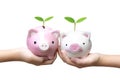 Two kids holding piggy banks with green trees Royalty Free Stock Photo